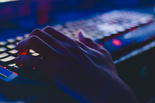 A person typing on a keyboard of a computer